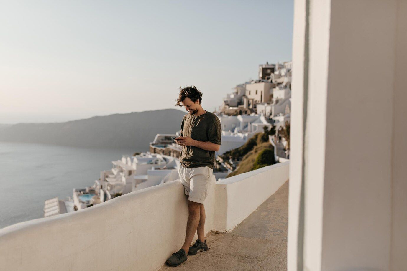 charming-man-white-shorts-dark-green-tshirt-chats-phone-outside-brunette-happy-guy-poses-city-sea-background_197531-30053.jpg