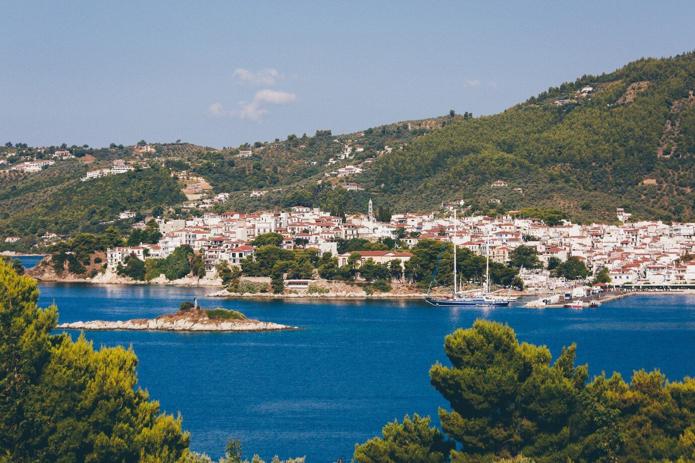 white-brown-houses-near-blue-ocean-surrounded-by-mountains-with-trees-skiathos-greece_181624-3133.jpg